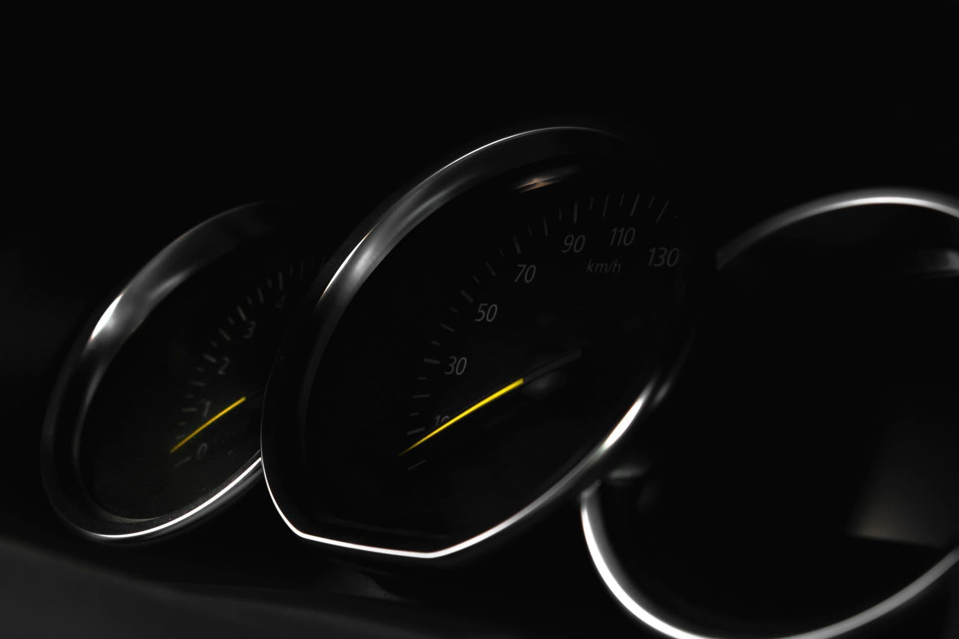 Detailed view of a vehicle speedometer in low light, showcasing speed measurement.